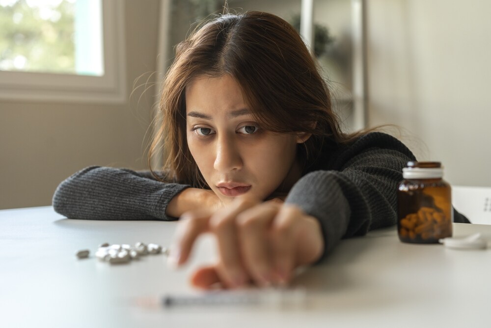 A young woman reaching for drugs. 