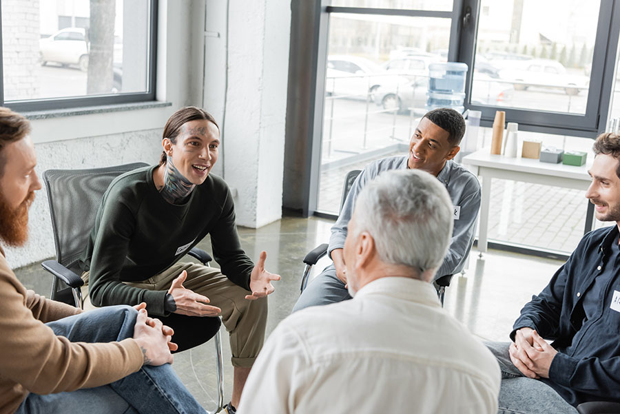 A cheerful man speaks during a group therapy session.