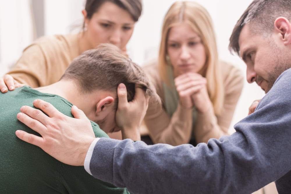 A group of people supporting a friend at an intervention.