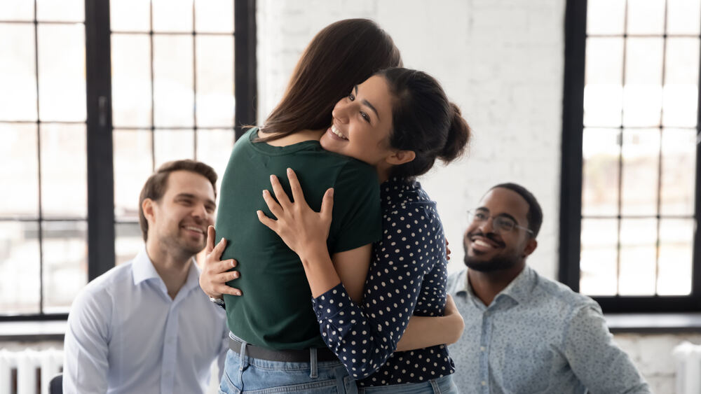 Two people hugging in group therapy