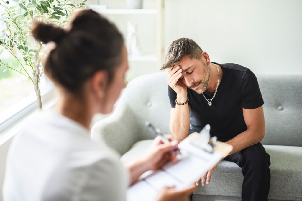 An upset man getting help from a therapist