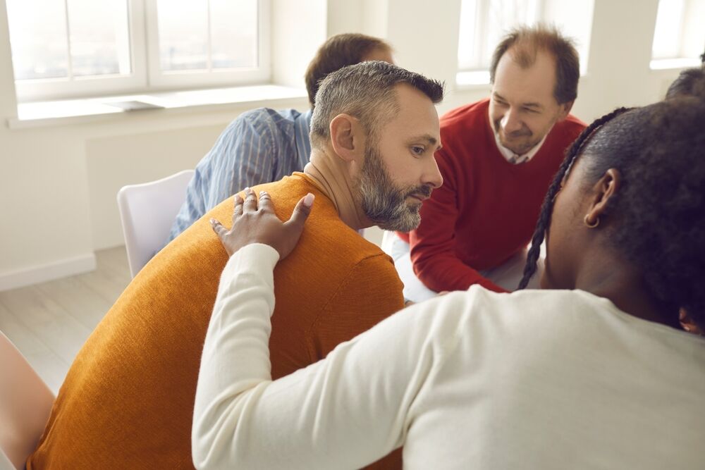 People supporting one another in group therapy 